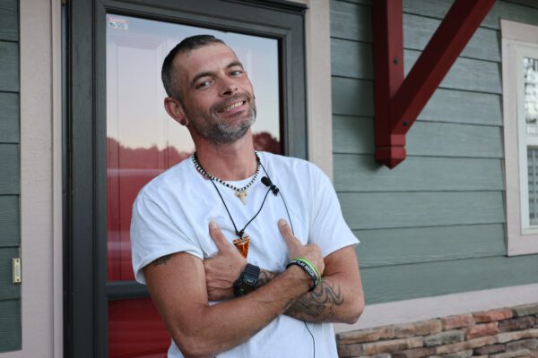 John in front of door - house number removed